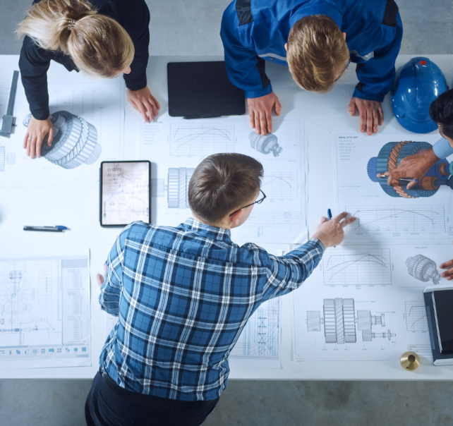 Team of Industrial Engineers Lean on Office Table, Analyze Machi